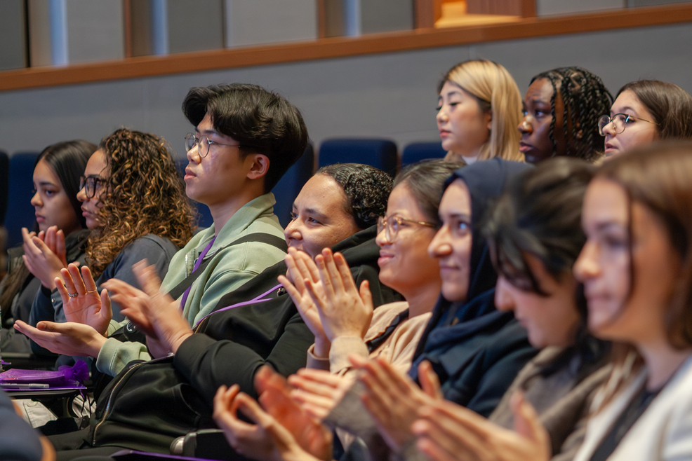 Students in auditorium, clapping